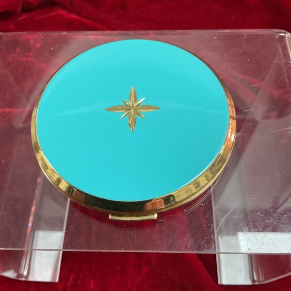 Vintage Stratton compact with turquoise enamel and gold starburst.