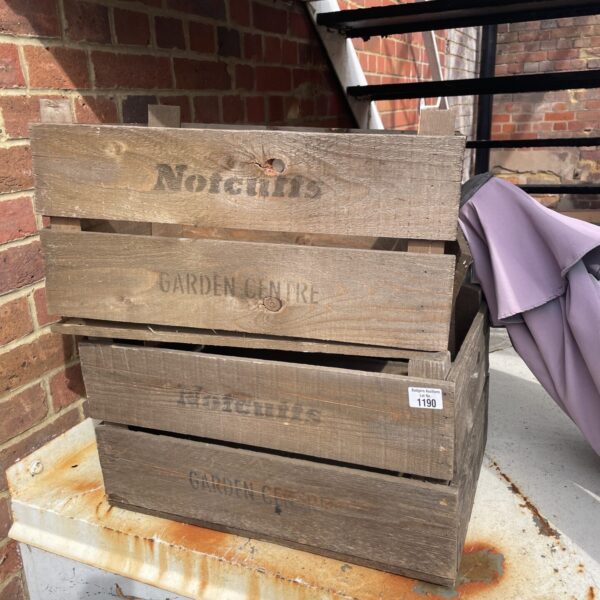 Stacked vintage Notcliffs Garden Centre wooden crates for storage.