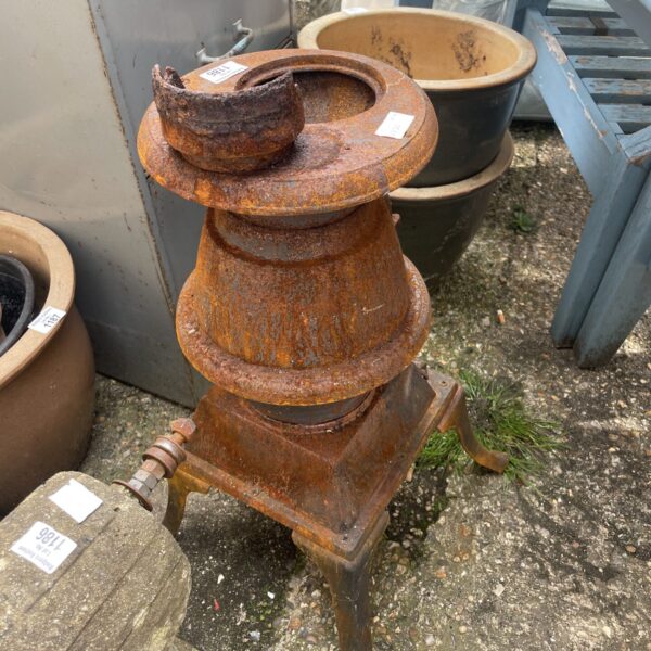 Antique cast iron fire burner with tiered design and ornate legs.