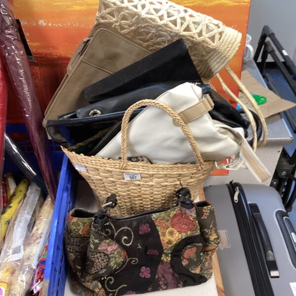 A lot of vintage ladies handbags in various styles and materials.