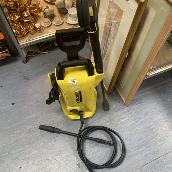 Front view of a used Karcher pressure washer with attachment.