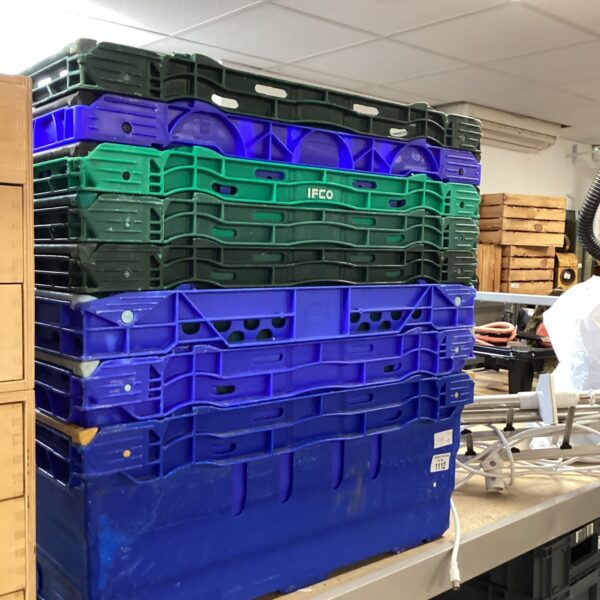 Stack of blue and green plastic storage crates for organization.