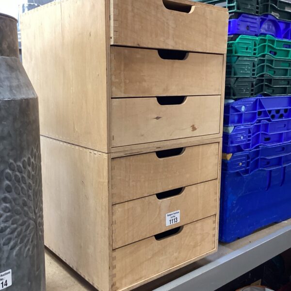 Wooden wheeled storage unit with multiple drawers for home organisation.