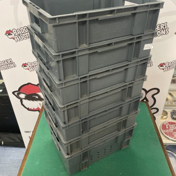 Stack of seven used Royal Mail plastic crates for storage.