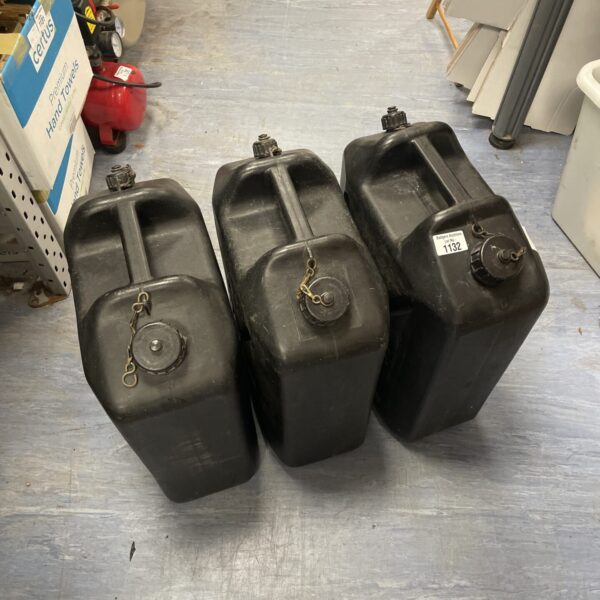 Three empty plastic jerry cans for portable fuel storage.