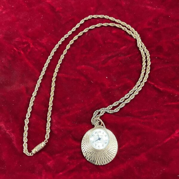 Vintage Seconda pendant watch on silver necklace, close-up view.