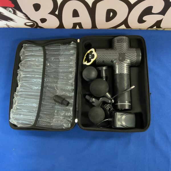 Grey massage gun with multiple attachments for muscle recovery.