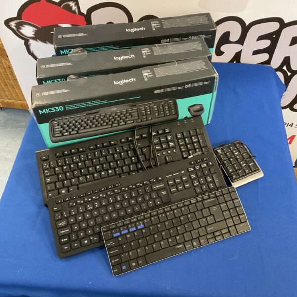 Lot of computer keyboards including Logitech MK330 model.