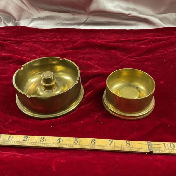 Vintage brass cannon shell ashtrays displayed with a ruler.