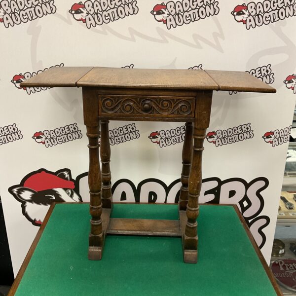 Antique oak folding leaf table with drawer, front view.