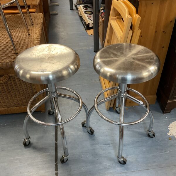 Pair of vintage stainless steel stools with castors.
