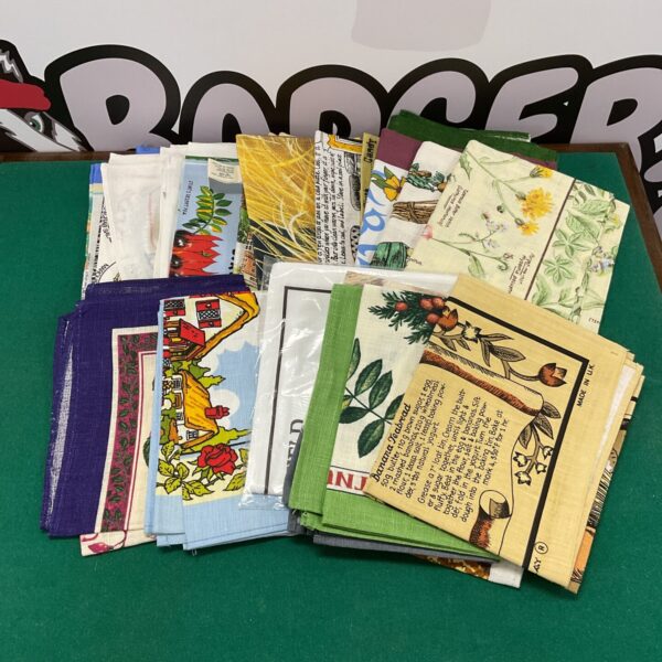 Vintage tea towel lot with colourful printed designs.