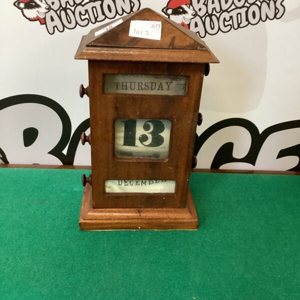 Antique wooden day date calendar with visible date display.