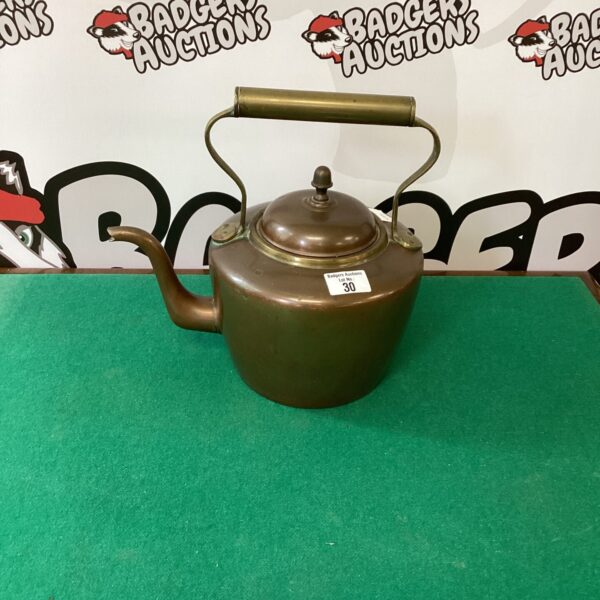 Vintage copper kettle with curved spout and handle.