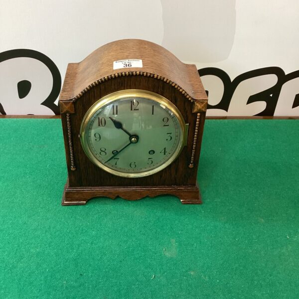 Vintage oak chiming clock with a classic face and hands.