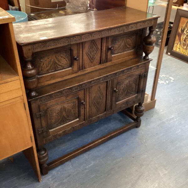 Antique 17th-century oak credence cupboard with carved details.