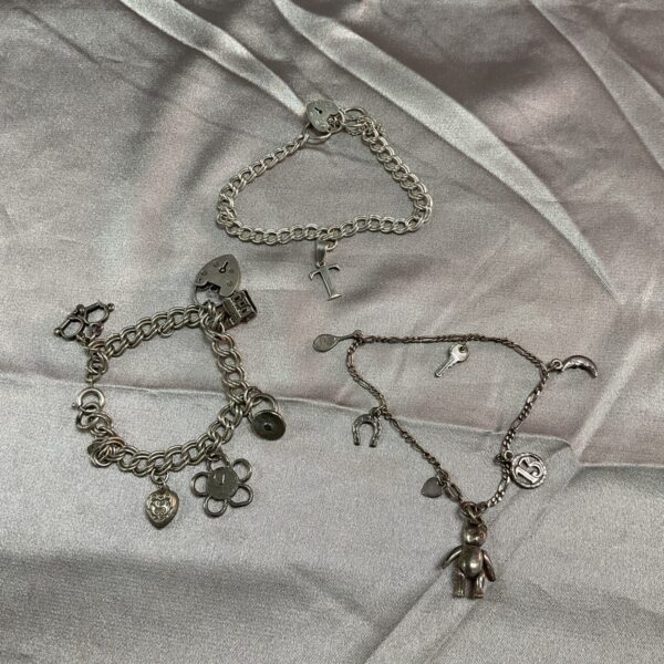 Silver charm bracelets lot with assorted vintage charms.
