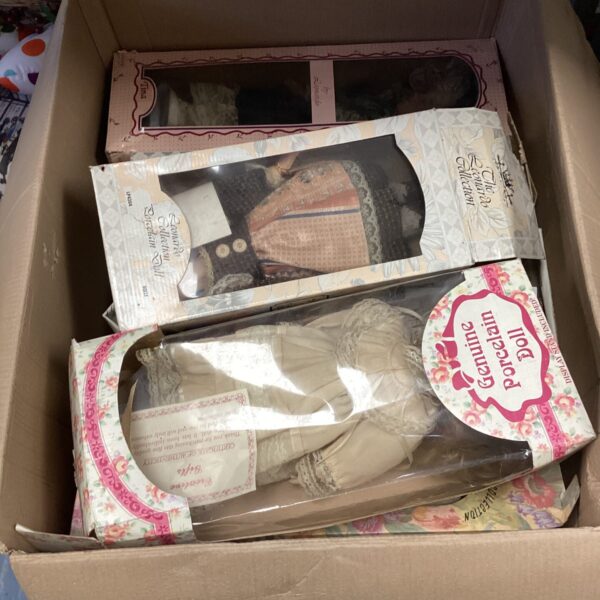 A box of vintage Leonardo Collection porcelain dolls.