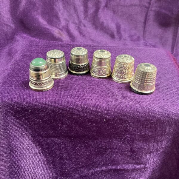 Lot of six vintage sterling silver thimbles with embossed patterns.