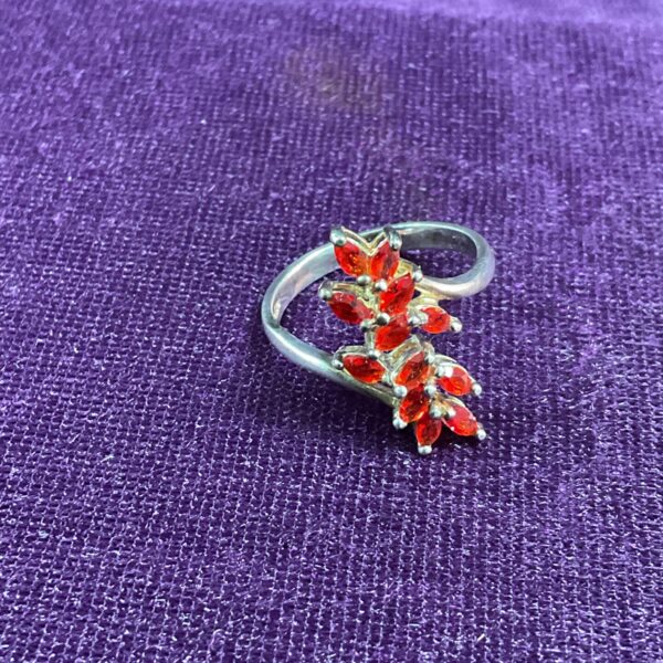 Silver ring with red stones in a crossover design.