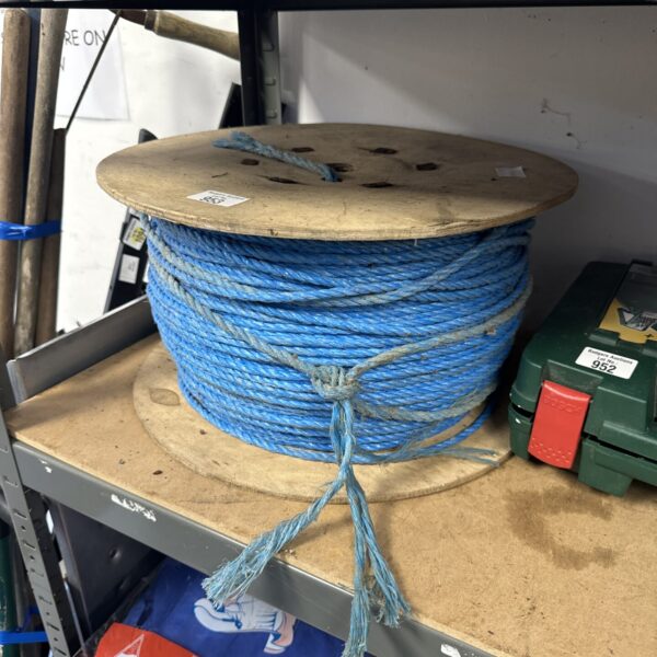 Large coil of blue nylon rope on a wooden spool.