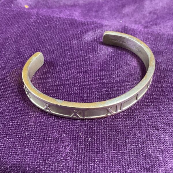 Silver tone Tiffany style cuff bracelet with Roman numerals.