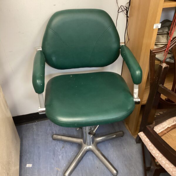 Vintage green leather barbers chair with five-star base.