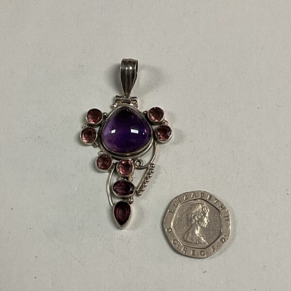 Silver pendant with amethyst and pink stones, floral design.