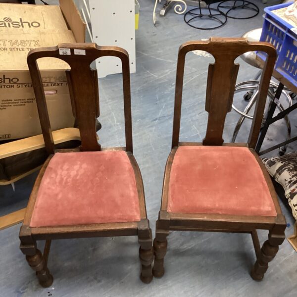 Two vintage wooden dining chairs with upholstered seats.