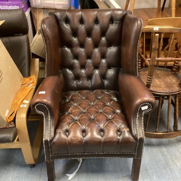 Vintage brown leather Scandinavian chair with rounded arms.