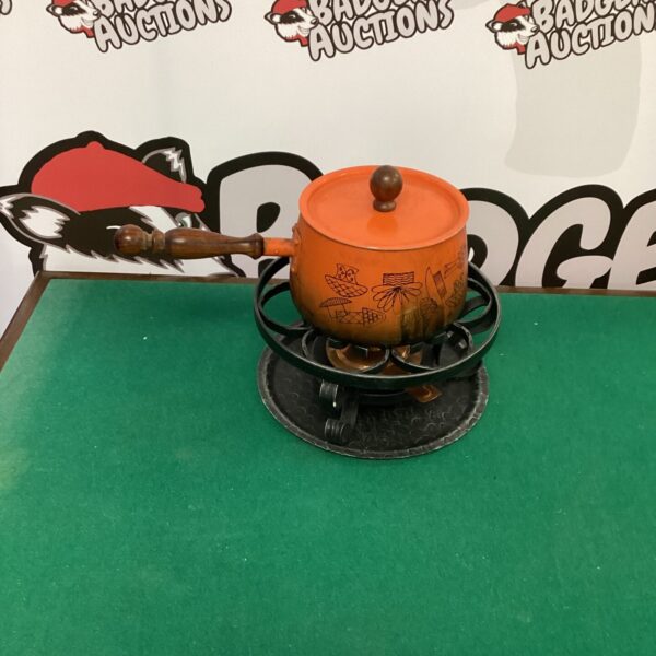 Vintage orange enamel fondue set with spirit burner on metal stand.