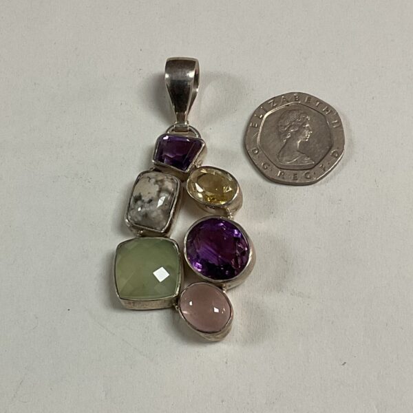 Close-up of a silver multistone pendant with amethyst and citrine.