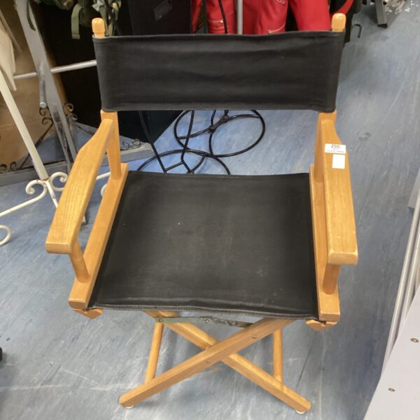 Vintage folding director's chair with black canvas seat.