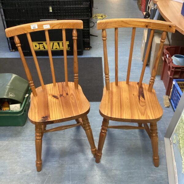 Two vintage pine stick back dining chairs with spindle backs.