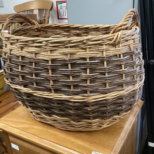 Large vintage wicker log basket for firewood storage.