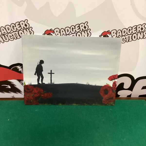 "Lest We Forget" painting depicting a soldier and cross.