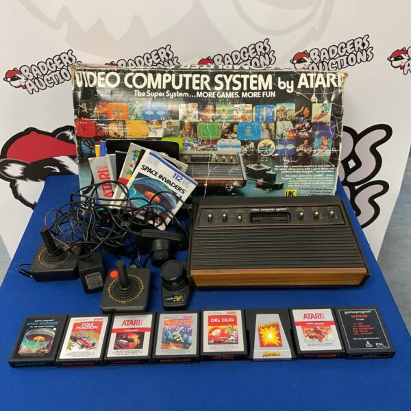 Vintage Atari 2600 woody console with joystick and game cartridges.