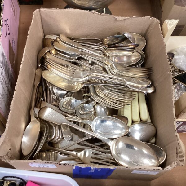 Vintage silverplate cutlery lot displayed in a cardboard box.