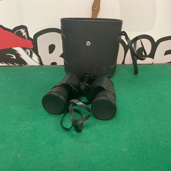 Vintage Prinz binoculars with a black finish and neck strap.
