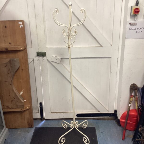 Vintage metal coat rack with curved arms and decorative design.