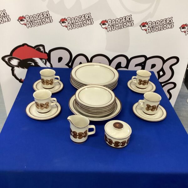 Vintage Japanese stoneware dinner set with floral design on display.