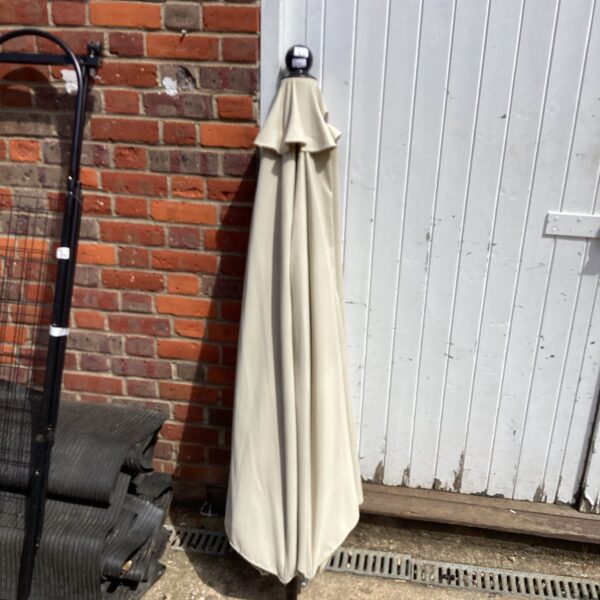 Large beige garden parasol providing outdoor shade.