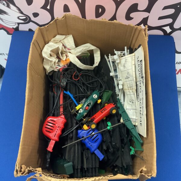 Vintage Scalextric track pieces in a cardboard box.