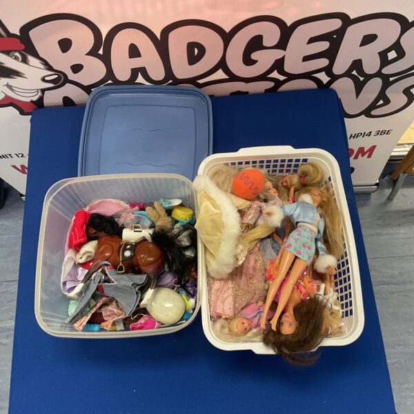 A tub filled with vintage Barbie dolls and various accessories.