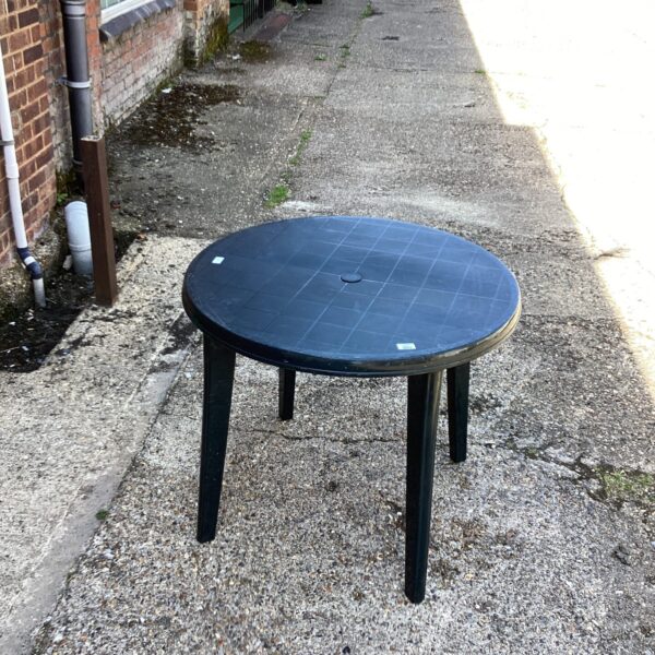 Brown plastic garden table in an outdoor setting.