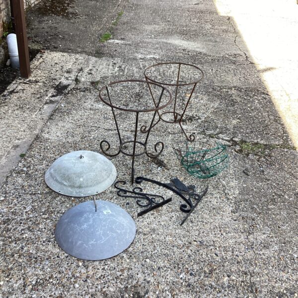 Weathered garden metalwork collection with hanging basket brackets.