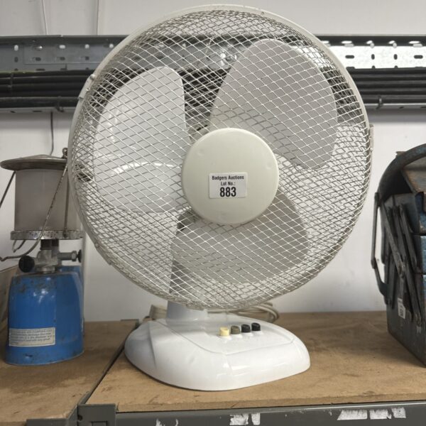 Unbranded desk fan on a table, vintage cooling appliance.