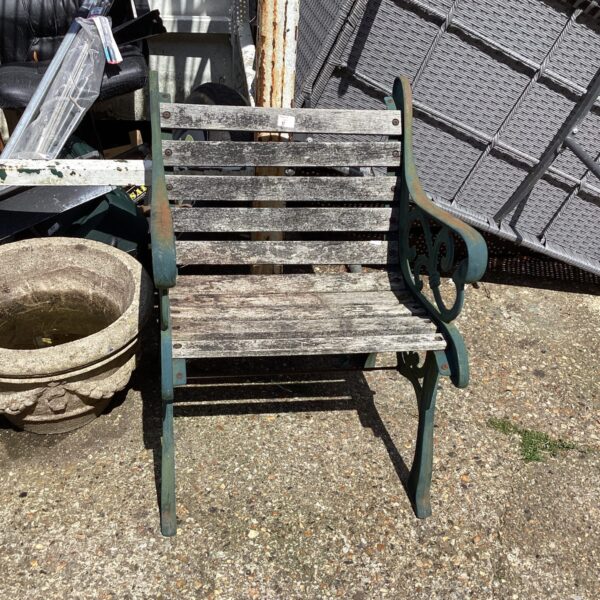 Antique wrought iron garden seat with slatted design.