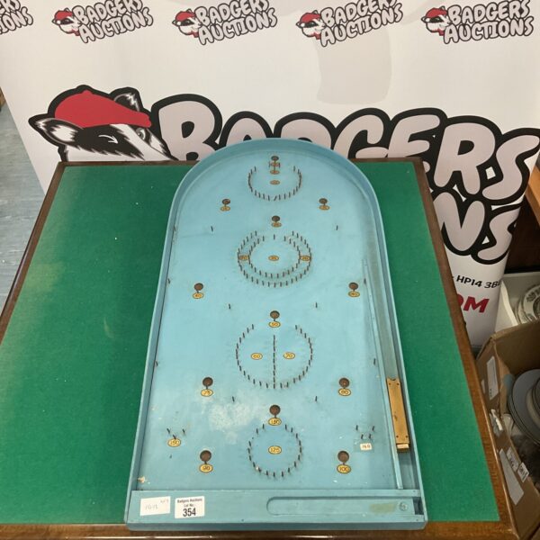 Vintage bagatelle game with numbered scoring holes and balls.
