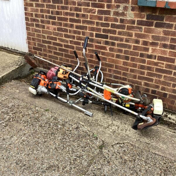 Job lot of vintage petrol strimmers for garden maintenance and restoration.
